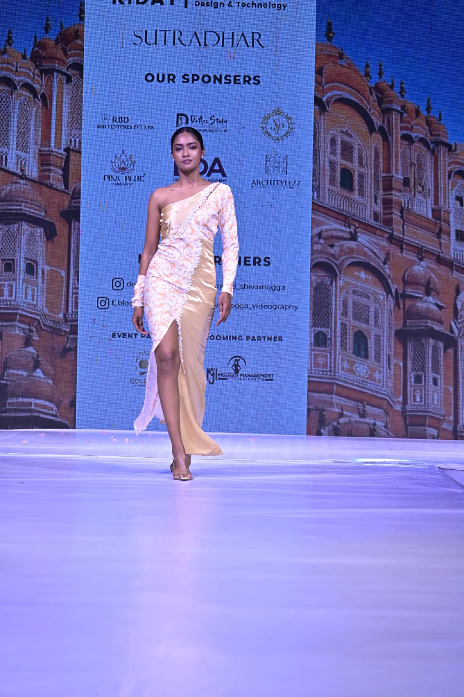 A look from Sutradhar 2025 in front of the sponsor backdrop